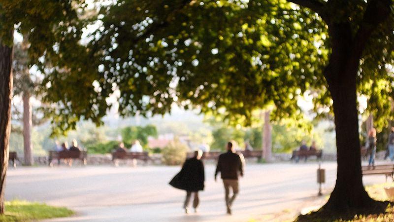 6 минуттық жүру тесті үшін телефон мен секундомері бар адам тегіс жолмен жүріп келеді