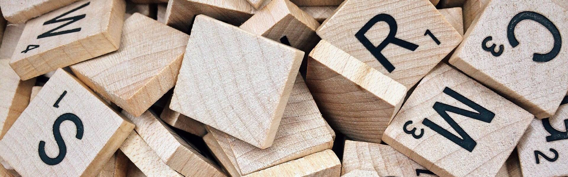 Wooden letter tiles with Latin letters scattered in a pile
